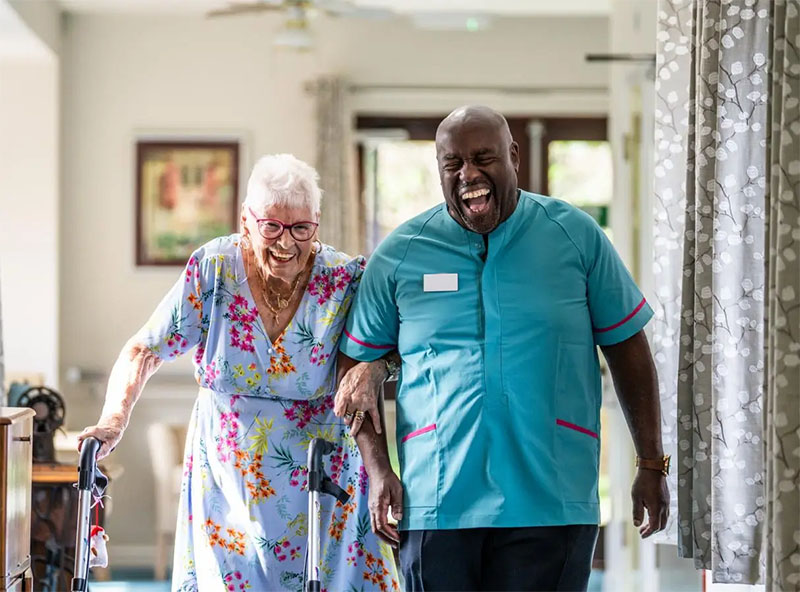 Smiling carer with older person and family